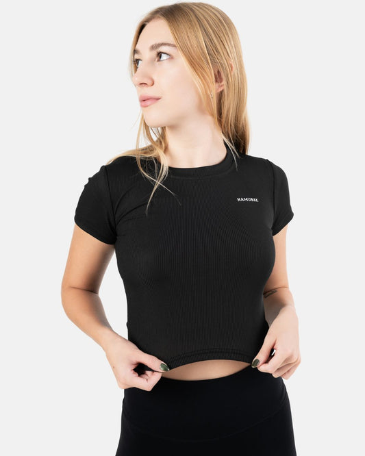 Foto de una mujer utilizando un croptop negro reciclado Namubak. Un cropto ideal para explorar