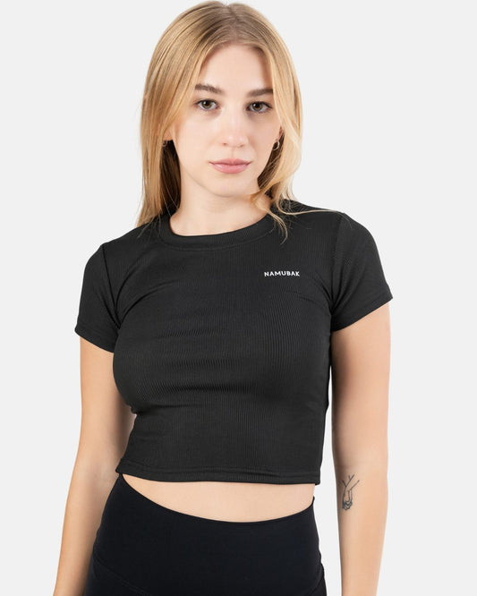 Foto de una mujer utilizando un croptop negro reciclado Namubak. Un cropto ideal para explorar