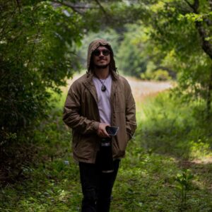 Foto de un hombre posando utilizando una Cortavientos en el Bosque