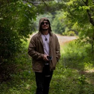 Foto de un hombre posando utilizando una Cortavientos en el Bosque