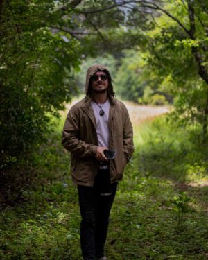 Foto de un hombre posando utilizando una Cortavientos en el Bosque