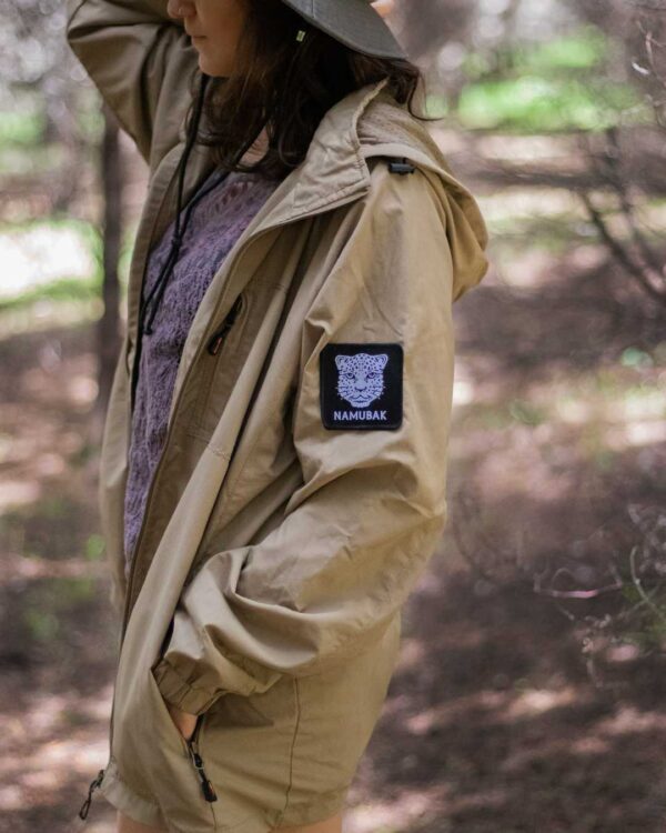 Foto de una mujer posando utilizando una Cortavientos en el Bosque