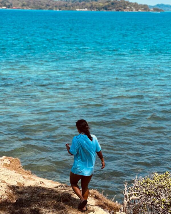 Foto de una mujer viendo el oceano y utilizando una camisa de Un Tiburon Martillo