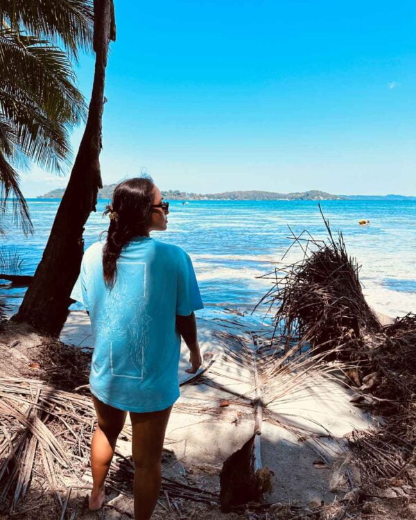 Foto de una mujer viendo el oceano y utilizando una camisa de Un Tiburon Martillo